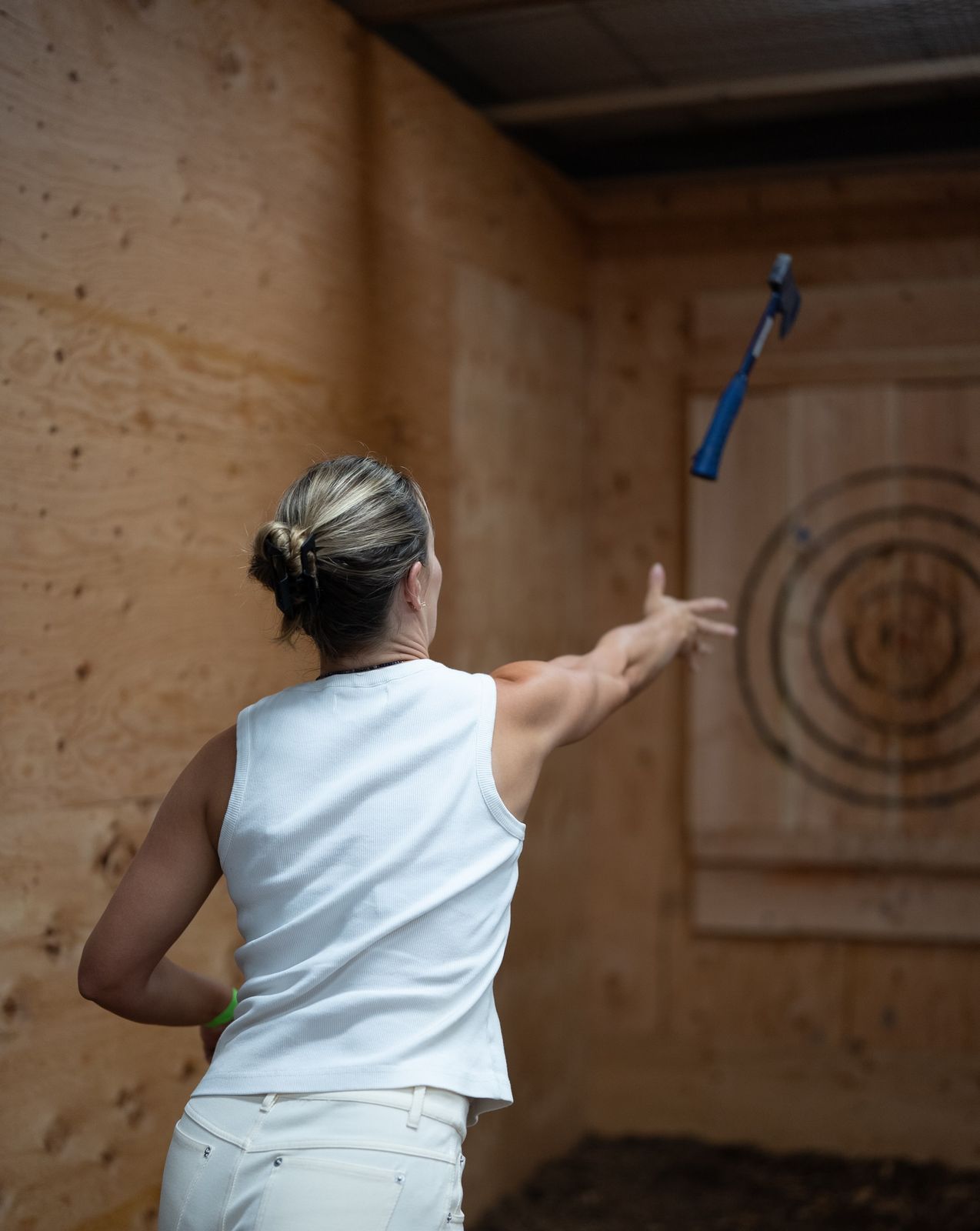 A guest throwing an axe at a wooden target in Oceanside