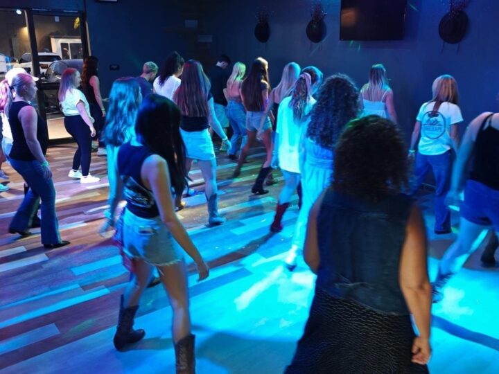 Guests line dancing under colored lights on Tuesday night