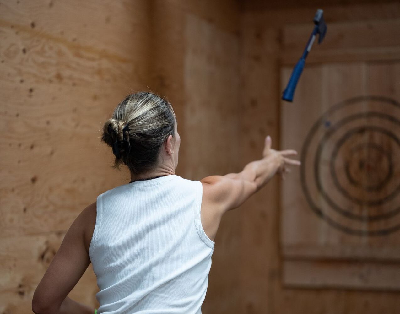 A guest throwing an axe at a wooden target at Chopscape